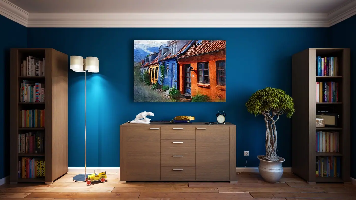 Wooden dresser between two bookcases on a blue wall